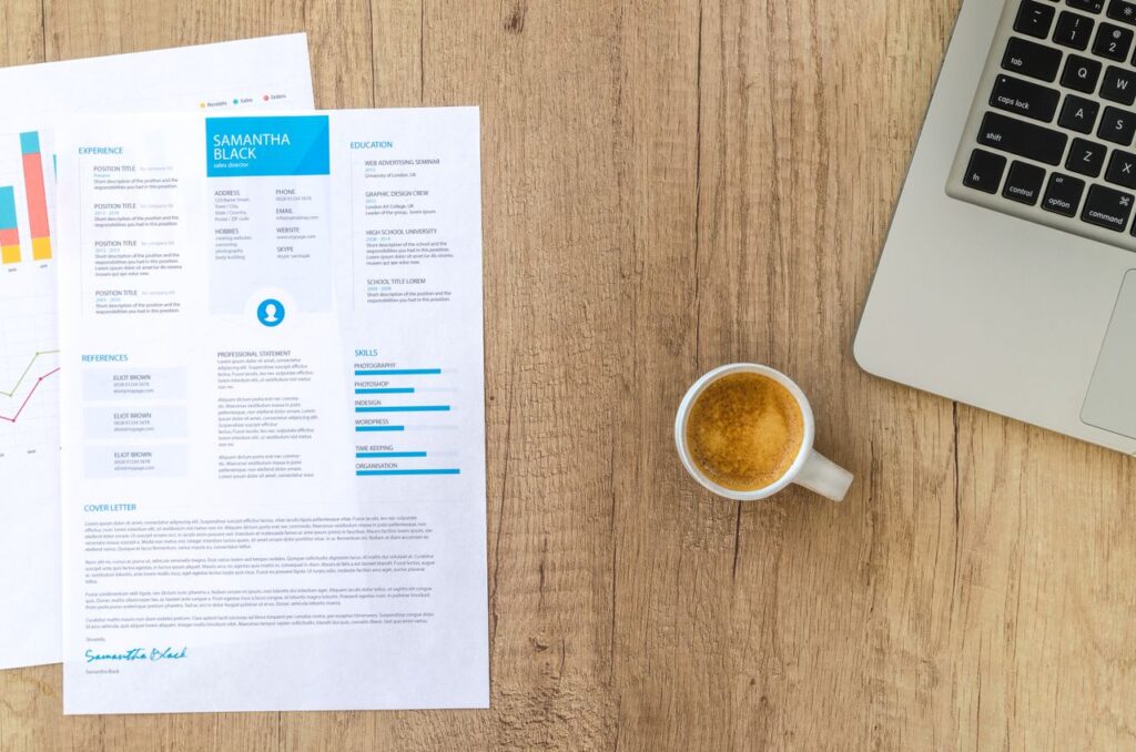 UK-standard two-page CV layout on a desk next to a laptop