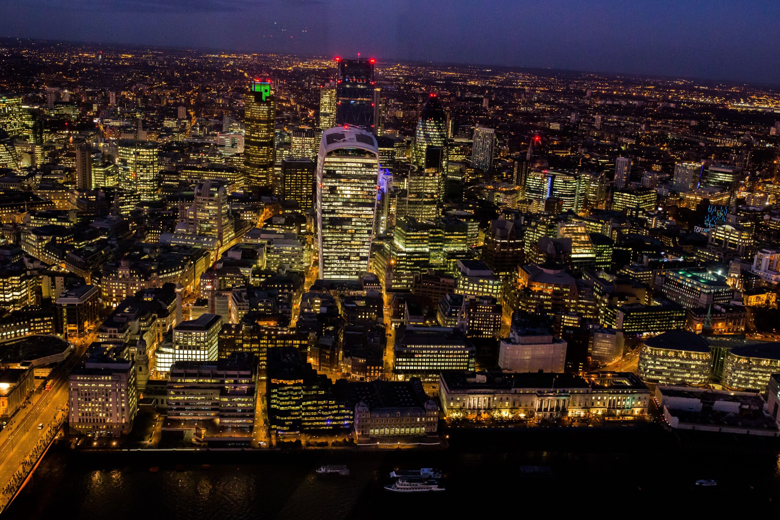 Project management salary uk career path: Aerial night view of London financial district skyline representing corporate sector transitions.